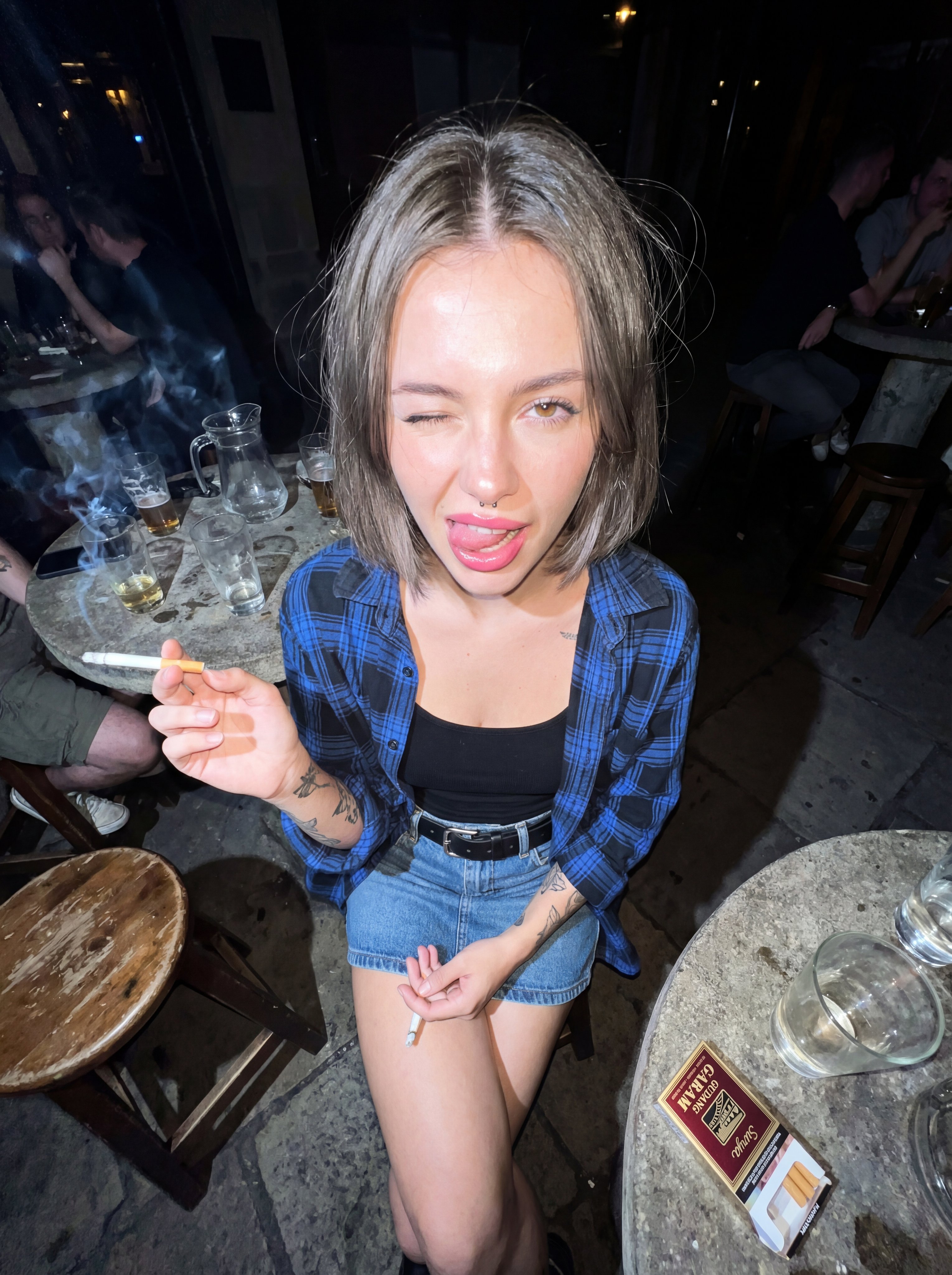 Young Woman in a Dark Outdoor Pub at Night - AI generated image